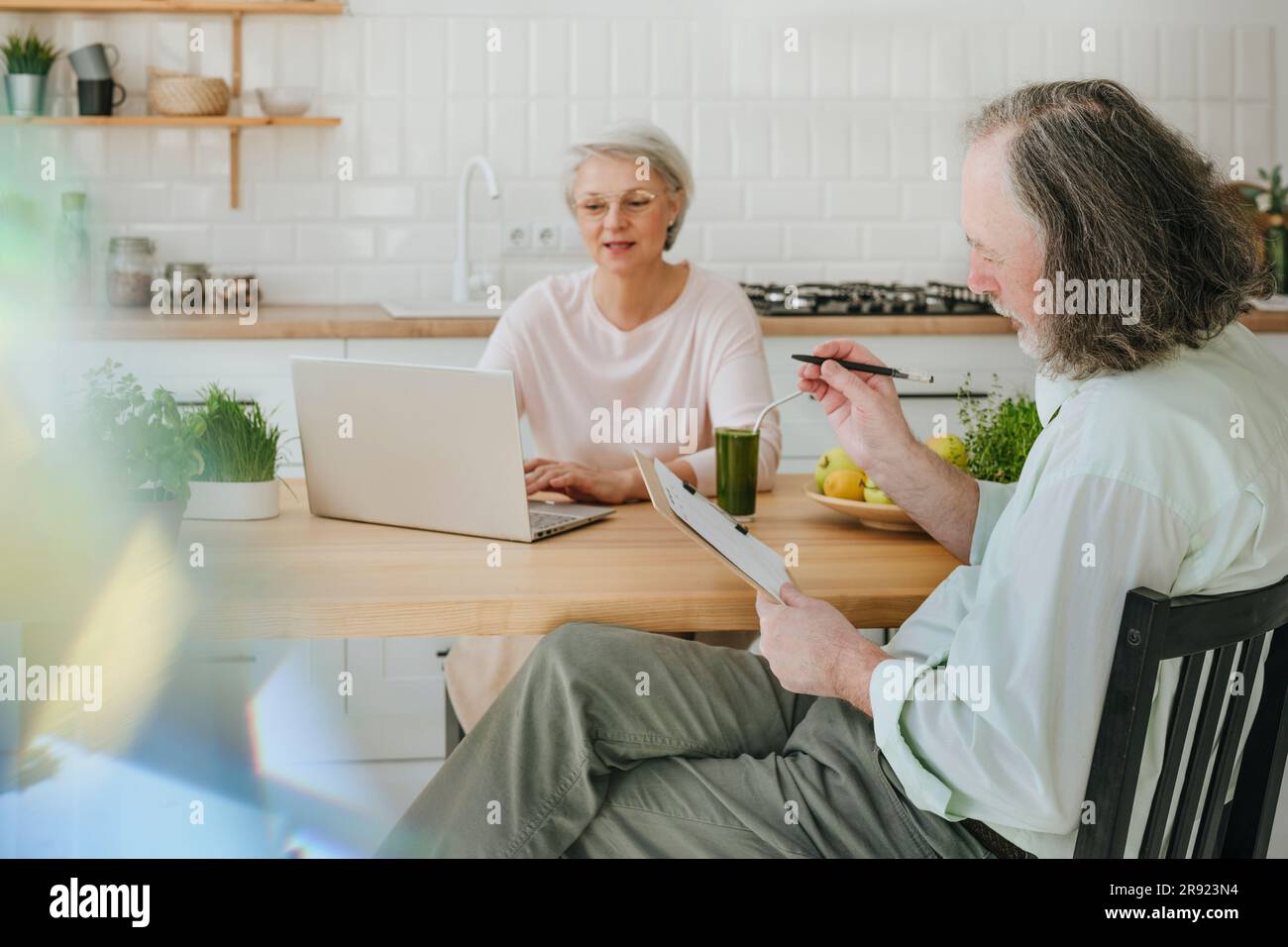 Uomo che parla con un nutrizionista che lavora a casa con un notebook Foto Stock