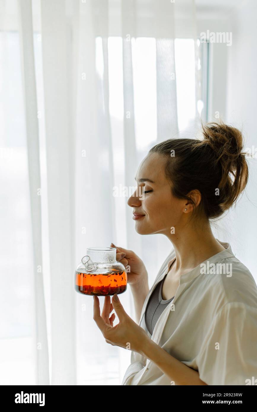 Donna che puzza di tè appena fatto a casa Foto Stock