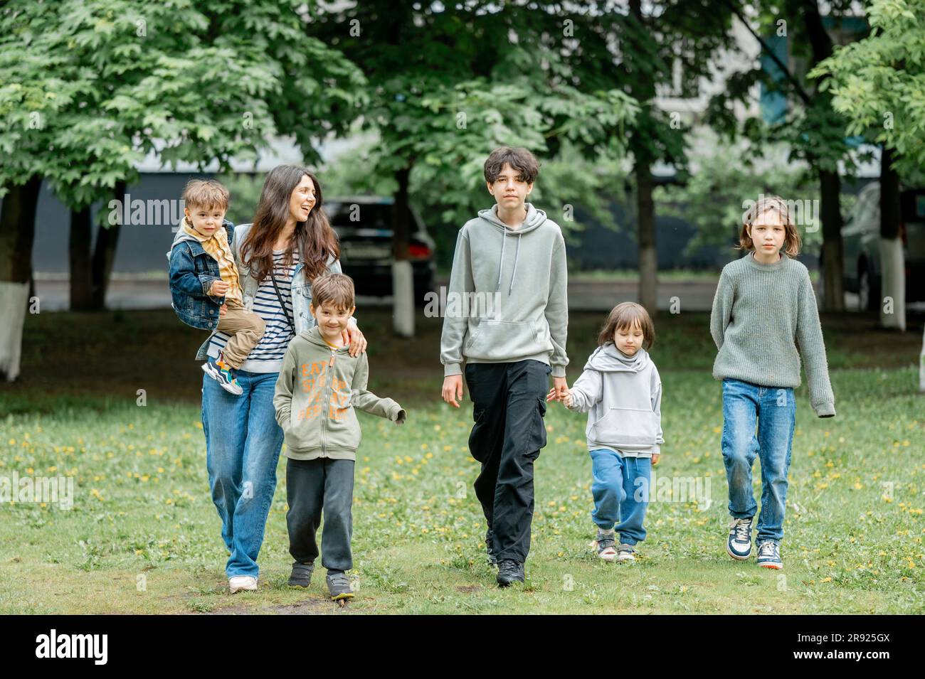 Mamma felice che cammina con i bambini nel parco Foto Stock