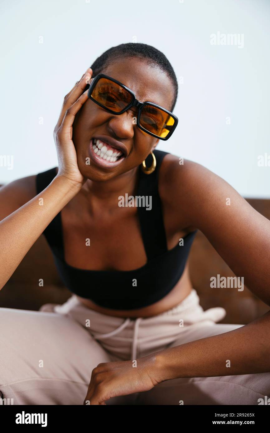 Giovane donna con i capelli corti che stringono i denti Foto Stock