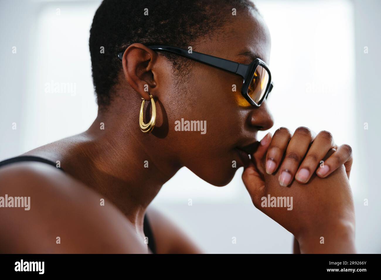 Giovane donna premurosa con le mani stringute Foto Stock