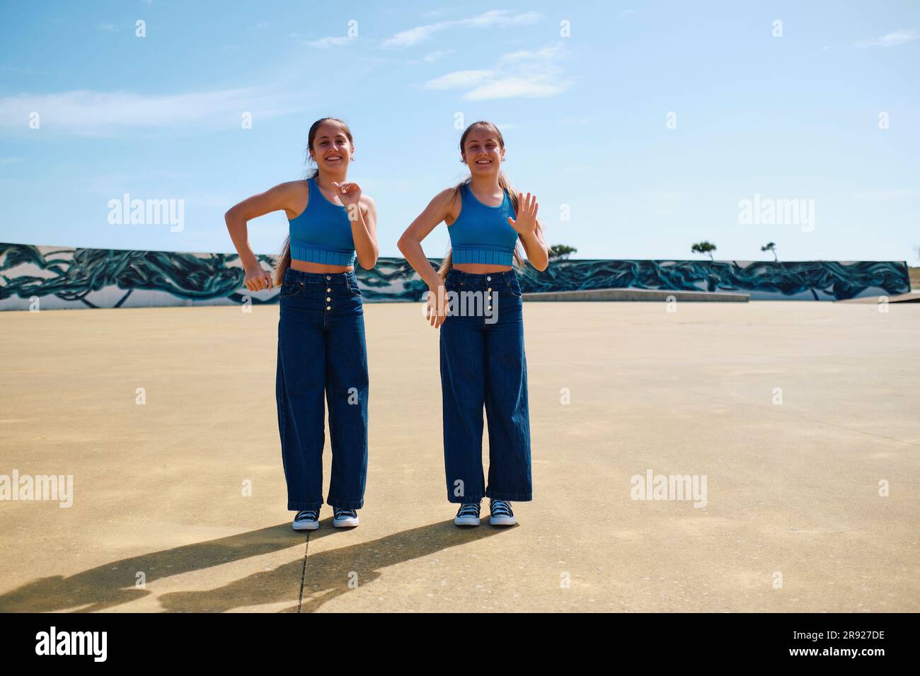 Sorelle gemelle che ballano insieme nella giornata di sole Foto Stock