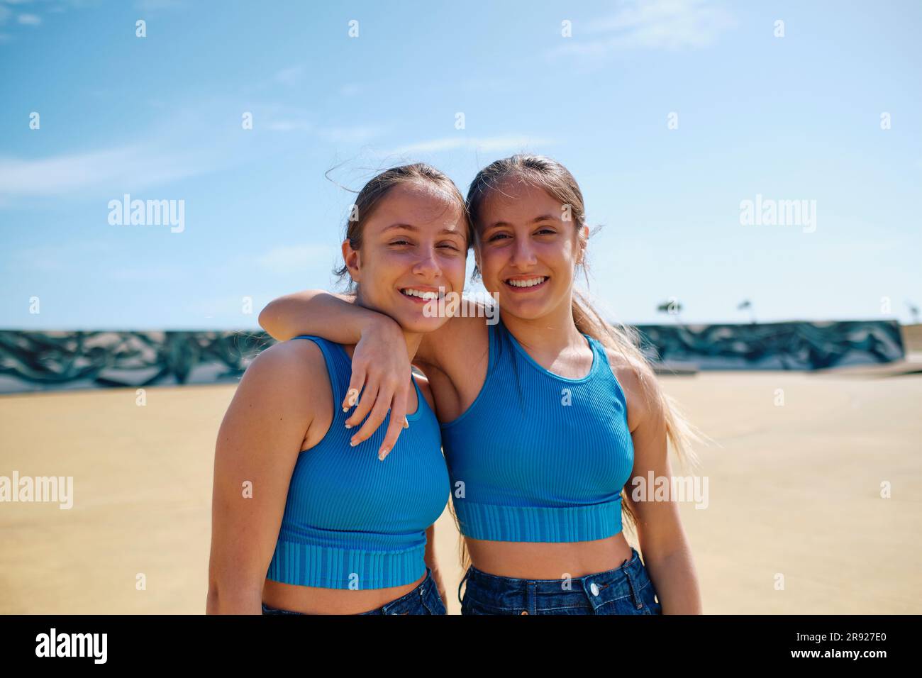 Felici sorelle gemelle in piedi insieme nella giornata di sole Foto Stock