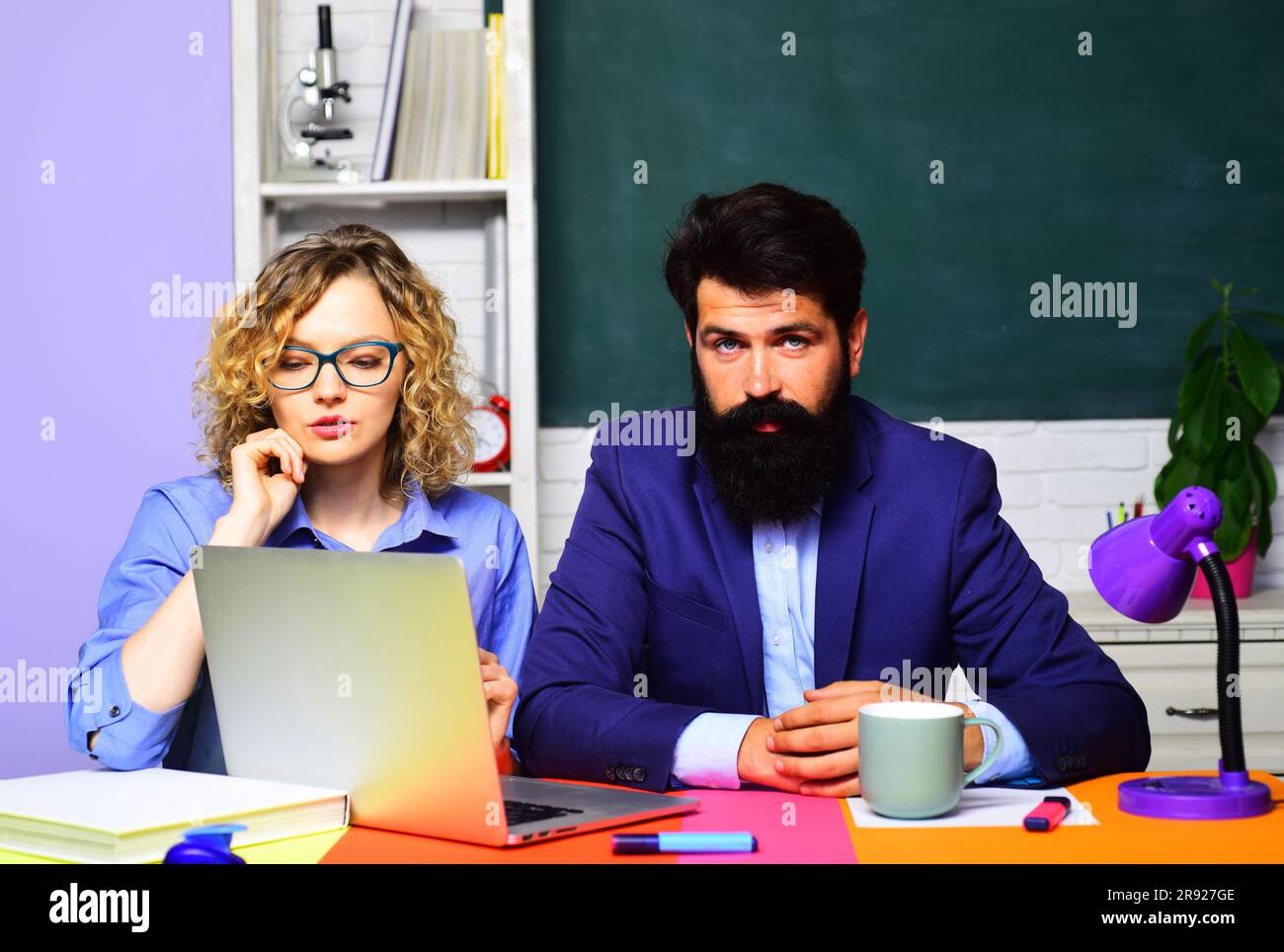 Insegnanti maschili e femminili in classe. Insegnanti professionisti o professori universitari sul posto di lavoro. Giornata mondiale degli insegnanti. Giornata della conoscenza. Coppia studenti Foto Stock