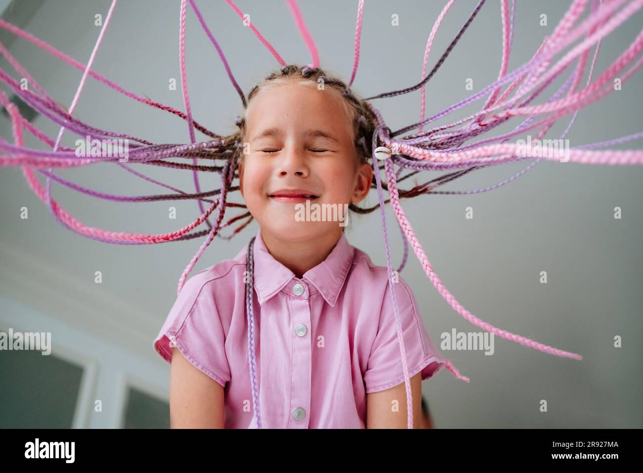 Ragazza sorridente con i capelli stillati a casa Foto Stock