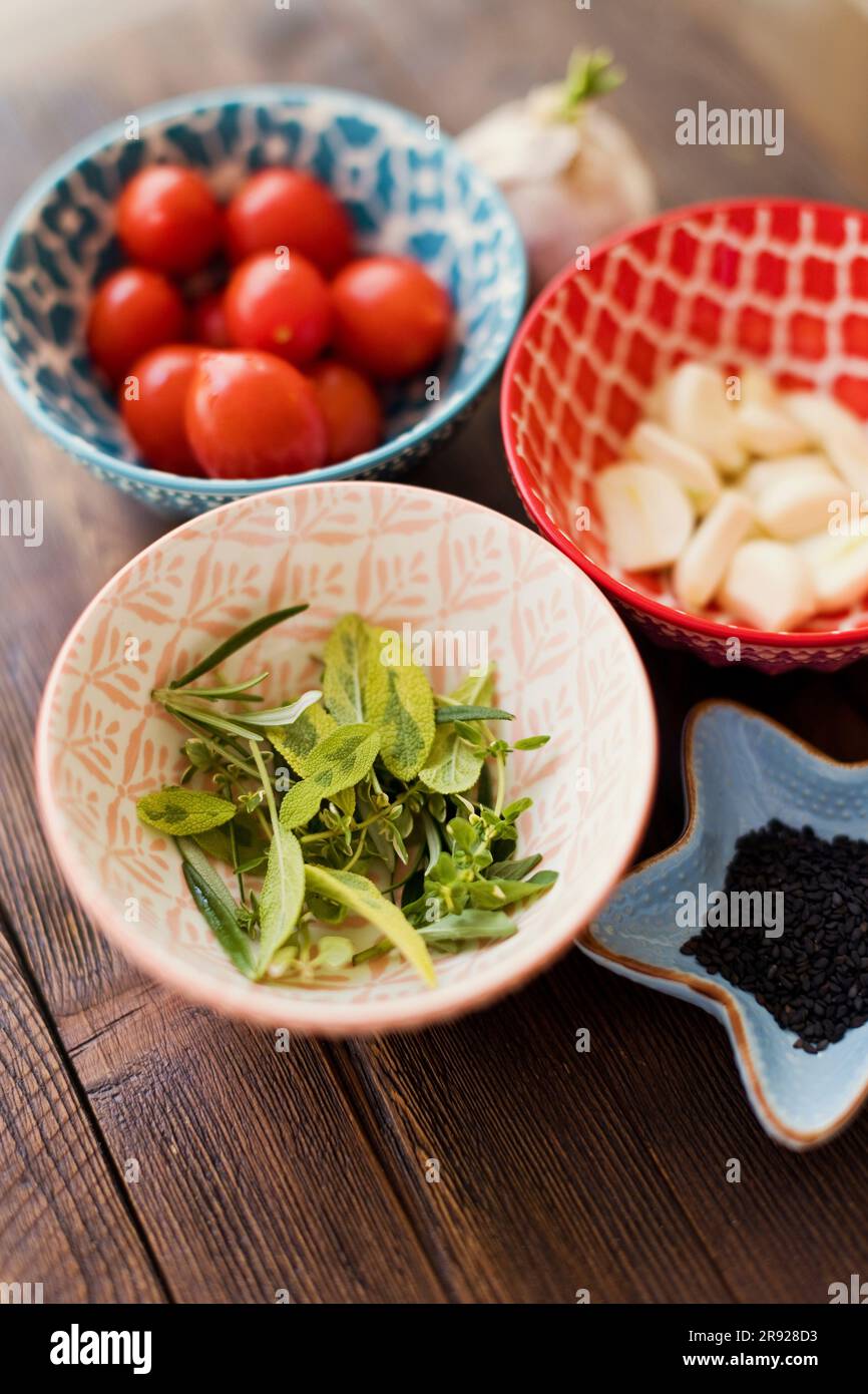 Ciotole multicolore con ingredienti tenuti sul tavolo Foto Stock