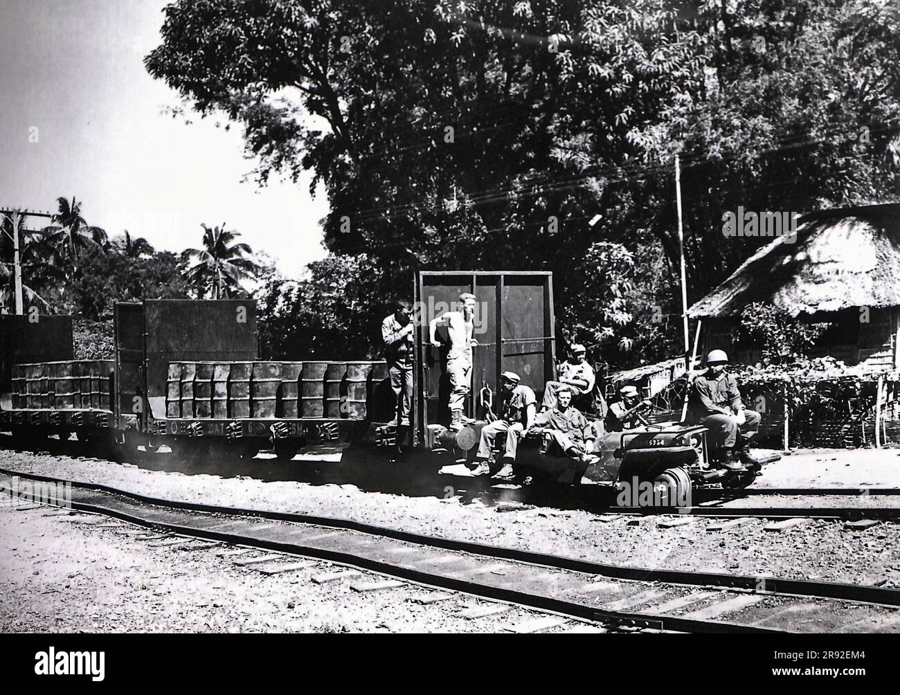 Una Jeep, adattata ai binari, trasporta un treno a tre carrozze merci, caricato di benzina, in un'area di combattimento sull'isola di Luzon durante la battaglia per le Filippine nella seconda guerra mondiale Foto Stock