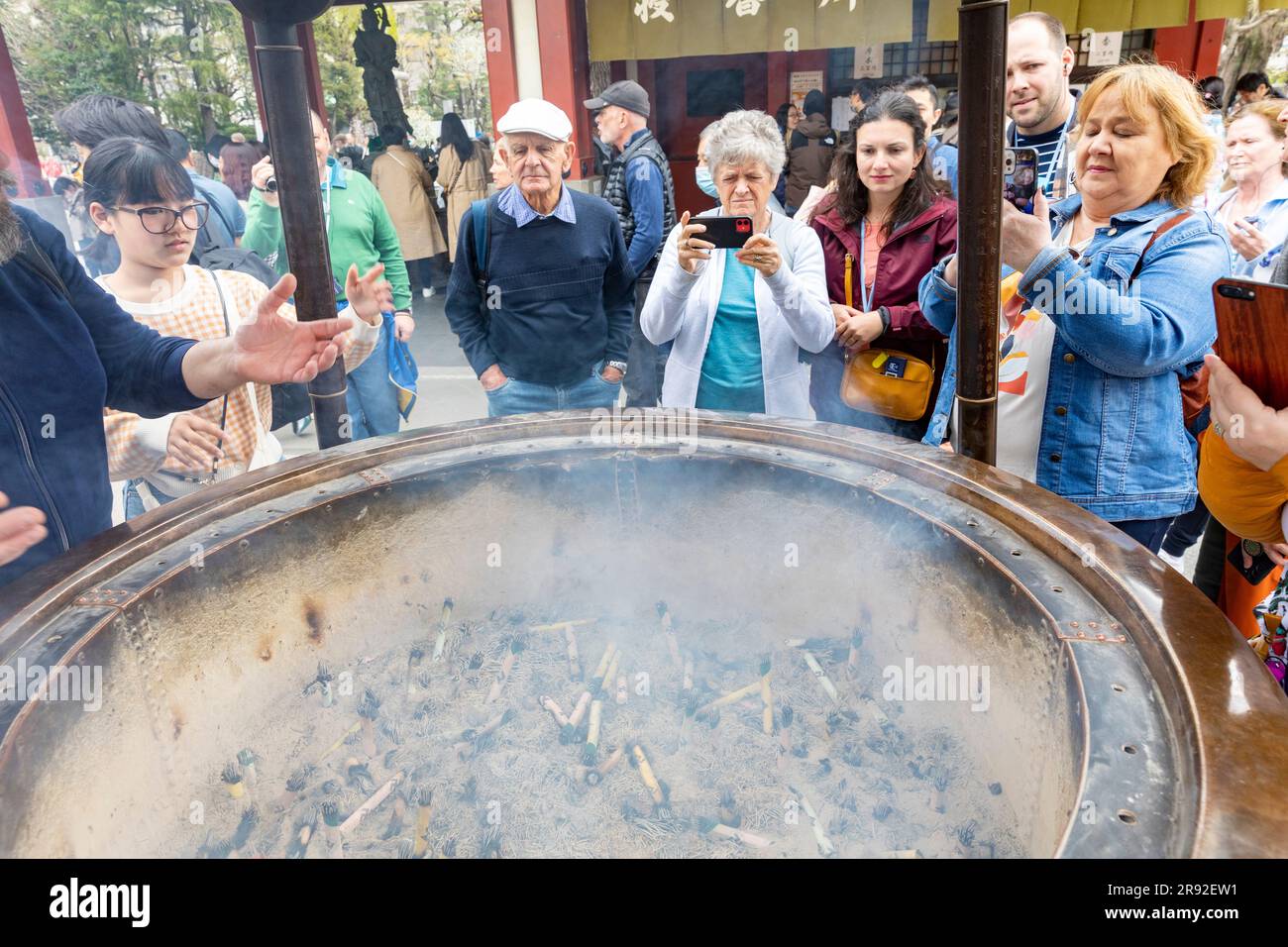 I giardini del tempio Asakusa Tokyo Sensoji si riuniscono per curarsi intorno al bruciatore di incenso jokoro, Tokyo, Giappone, Asia, 2023 Foto Stock