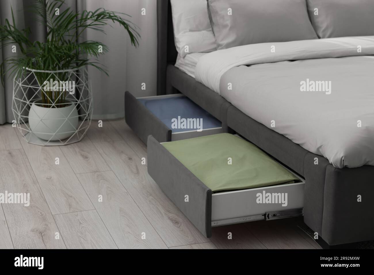 Cassetti ripostiglio con biancheria da letto sotto un letto moderno in  camera Foto stock - Alamy