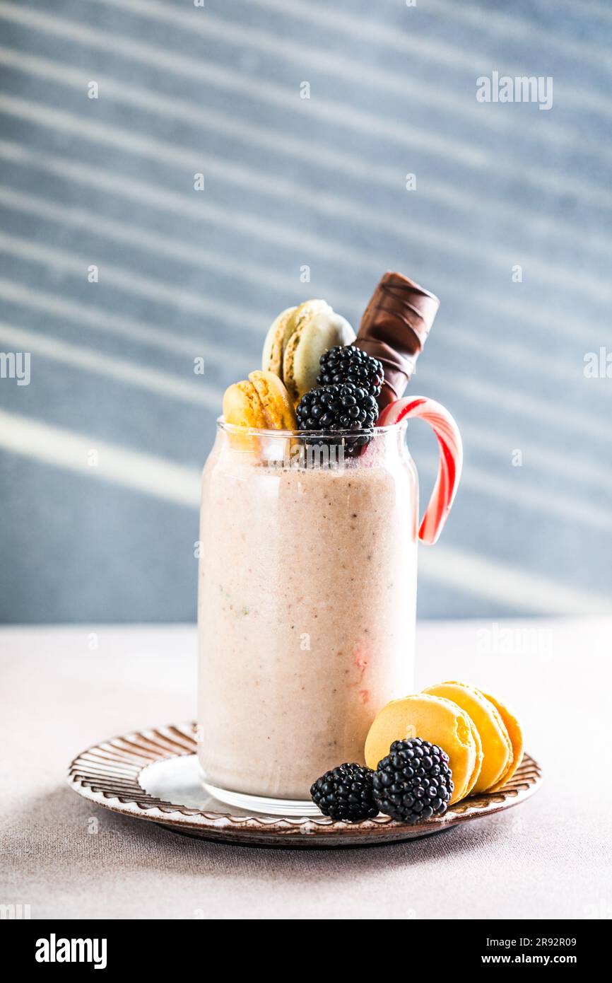 Frullato glassato al cioccolato con ciambelle e dolci. Folle freakshake alimentare tendenza. Spazio di copia Foto Stock