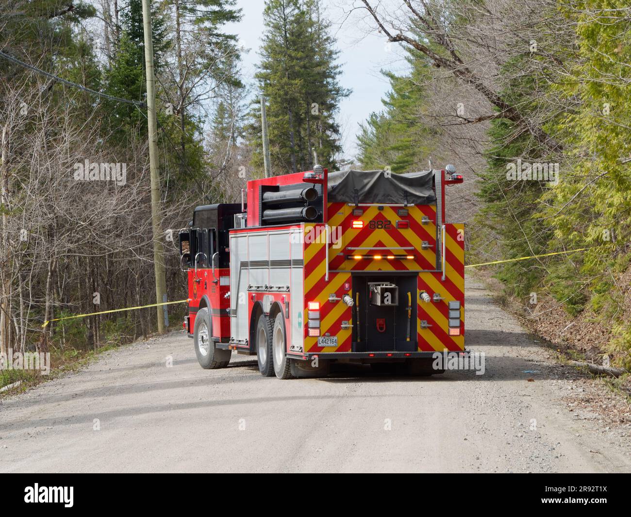 Camion dei vigili del fuoco che blocca una strada di ghiaia rurale in Quebec, Canada Foto Stock