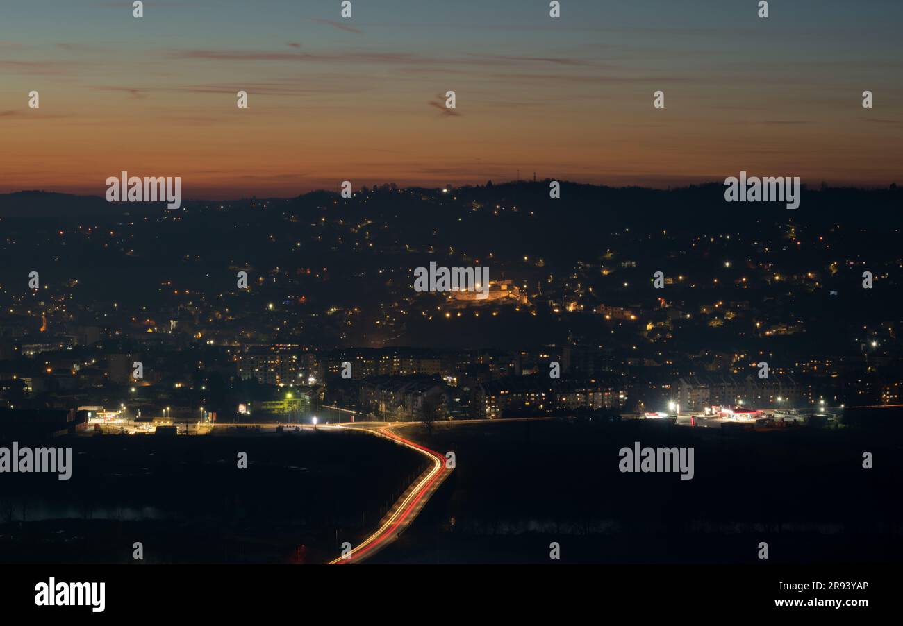 Paesaggio della città di Doboj sulla riva del fiume Bosna al crepuscolo, sentieri leggeri Foto Stock