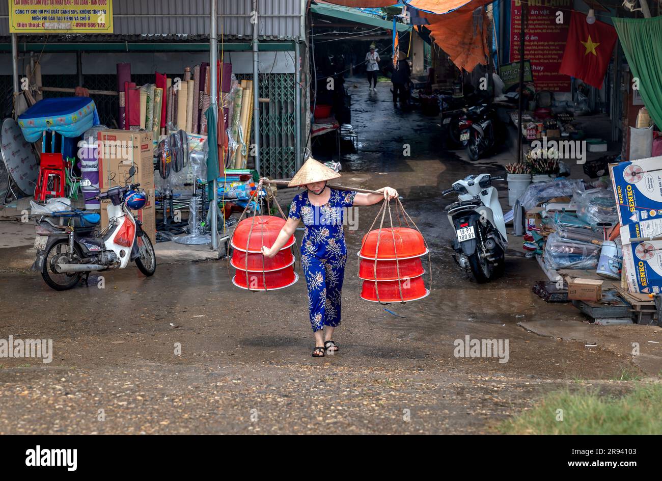 Una donna porta cibo in vendita in un mercato nella provincia di Phu Tho, in Vietnam Foto Stock