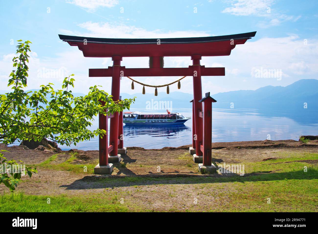 Lago Tazawa e porta Torii del santuario Ozaishi Foto Stock