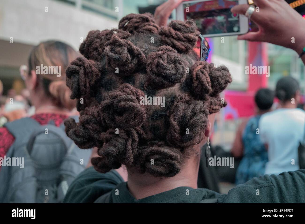 Donna nera con capelli Bantu Knots che filma sul cellulare Foto Stock