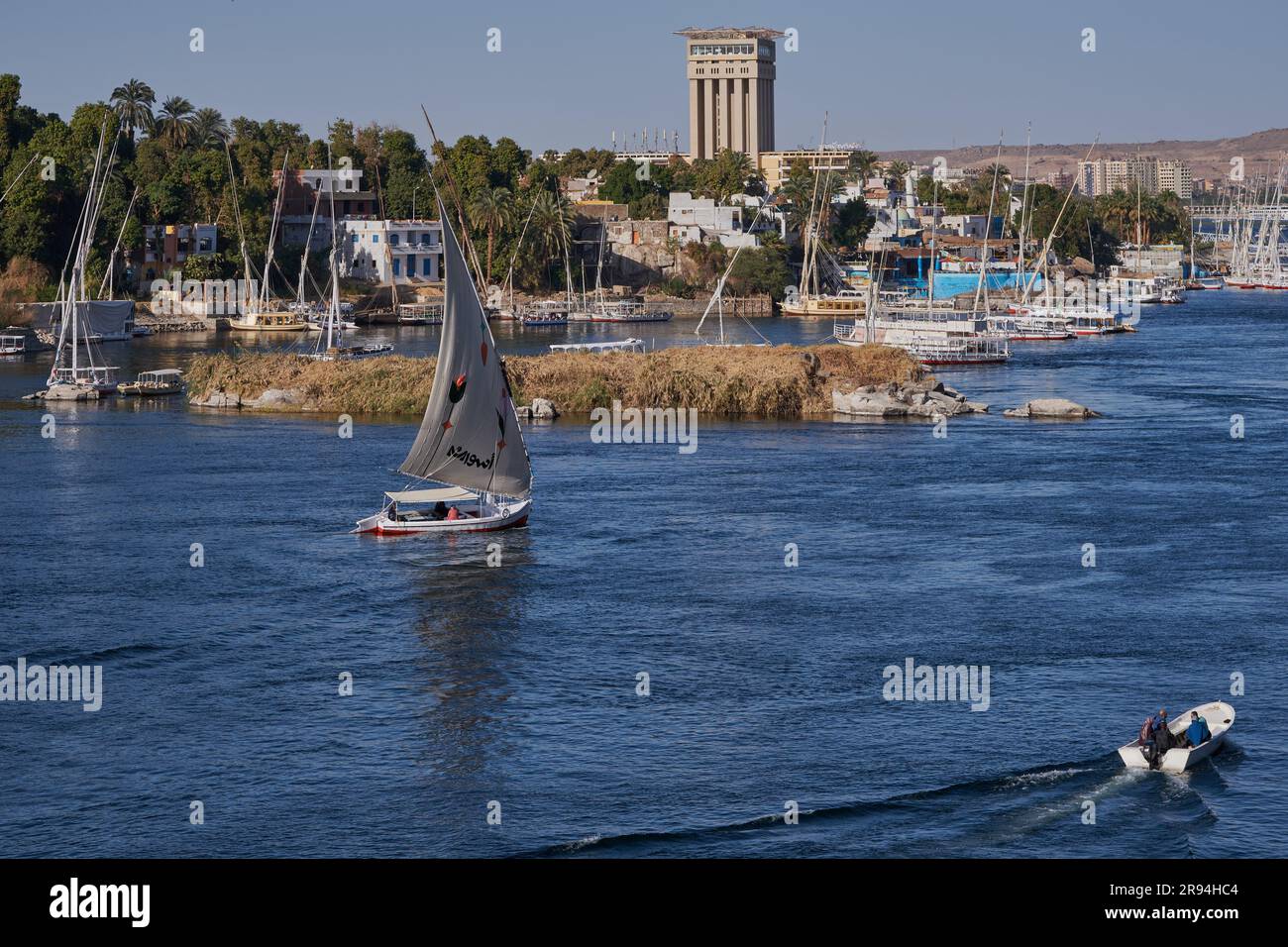 Foto pomeridiane del fiume Nilo ad Assuan, Egitto, che mostra feluche e barche nel fiume con l'isola degli elefantini (sito patrimonio dell'umanità dell'UNESCO) Foto Stock