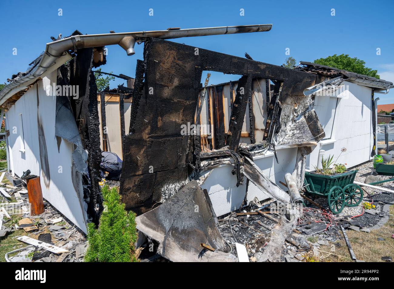 Jarmen, Germania. 24 giugno 2023. Vista delle rovine del fuoco di una casa di famiglia a Jarmen. Due persone sono morte nell'incendio dell'edificio residenziale a Jarmen (distretto di Vorpommern-Greifswald) sabato. Quando le forze di emergenza della polizia e dei vigili del fuoco arrivarono, l'edificio era già completamente in fiamme, come annunciato dalla polizia. Se i morti fossero i proprietari di una casa, un uomo di 60 anni e sua moglie di 59 anni, era ancora sconosciuto. Sabato, la polizia non ha ancora potuto fornire informazioni sulla causa dell'incendio. Crediti: Stefan Sauer/dpa/Alamy Live News Foto Stock