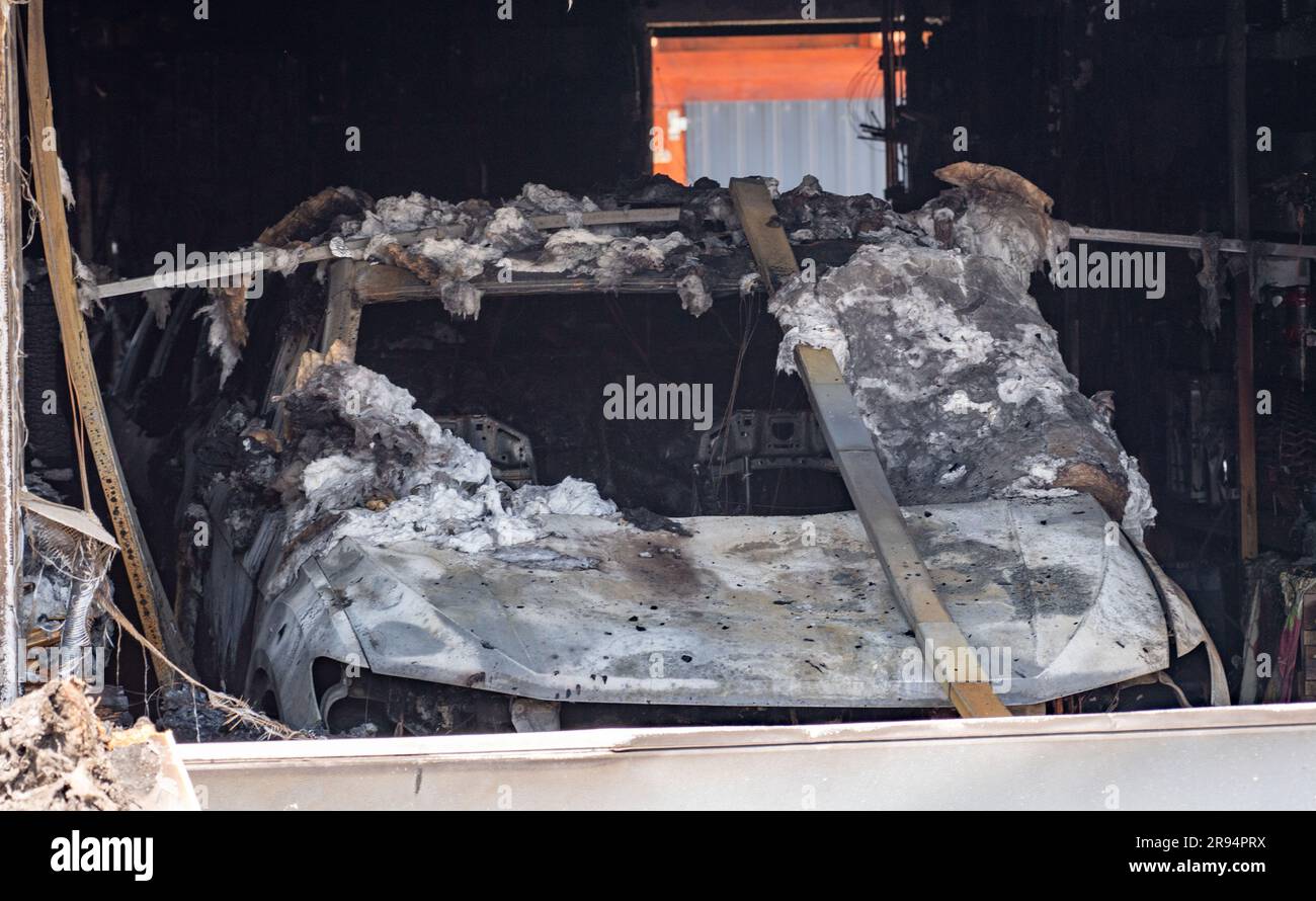 Jarmen, Germania. 24 giugno 2023. Un'auto bruciata sta in un garage alle rovine del fuoco di una casa di famiglia a Jarmen. Nell'incendio del condominio a Jarmen (distretto di Vorpommern-Greifswald) due persone sono morte il sabato. Quando le forze di emergenza della polizia e dei vigili del fuoco arrivarono, l'edificio era già completamente in fiamme, come annunciato dalla polizia. Se i morti fossero i proprietari di una casa, un uomo di 60 anni e sua moglie di 59 anni, era ancora sconosciuto. Sabato, la polizia non ha ancora potuto fornire informazioni sulla causa dell'incendio. Crediti: Stefan Sauer/dpa/Alamy Live News Foto Stock