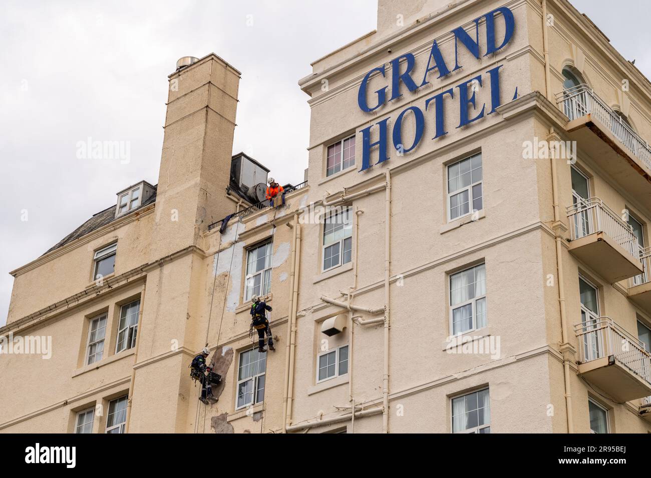 Pittori e decoratori specializzati dipingono il lato del Grand Hotel, Llandudno, Galles del Nord, Regno Unito. Foto Stock