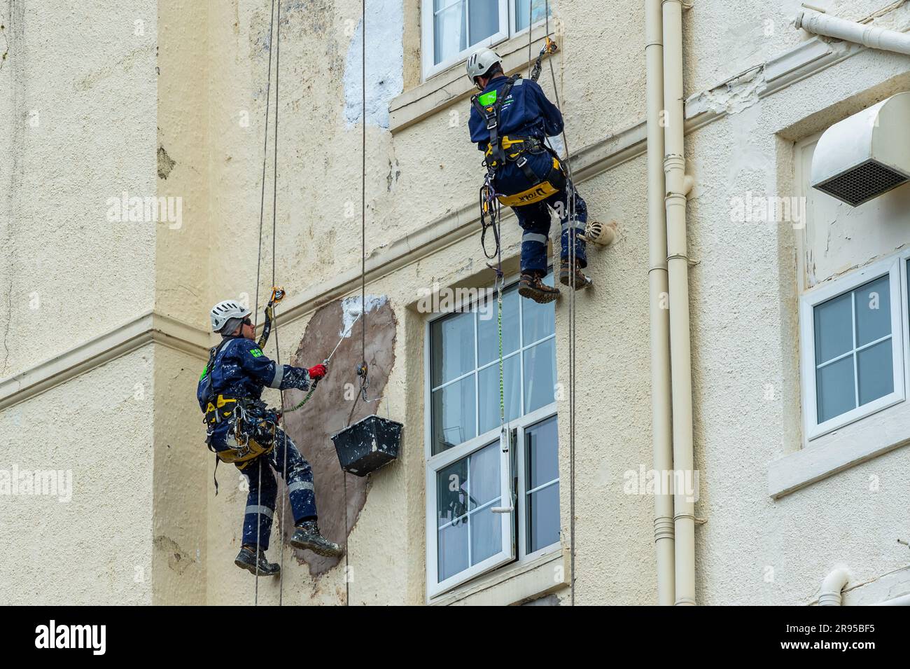 Pittori e decoratori specializzati dipingono il lato del Grand Hotel, Llandudno, Galles del Nord, Regno Unito. Foto Stock