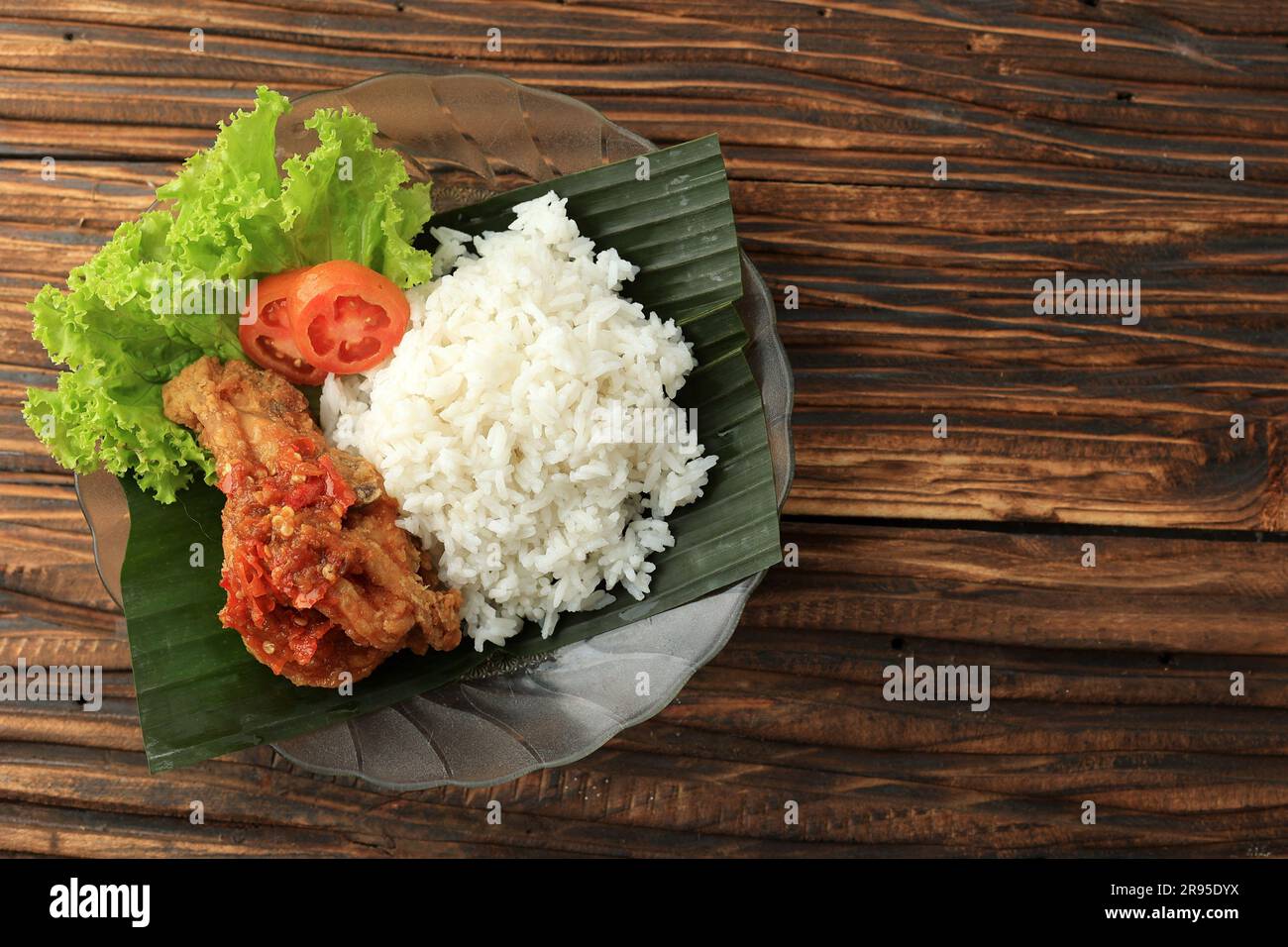Ayam Geprek Sambal BAwang con riso bianco al vapore. Cibo di strada popolare indonesiano, spazio di copia per testo, ricetta o pubblicità Foto Stock