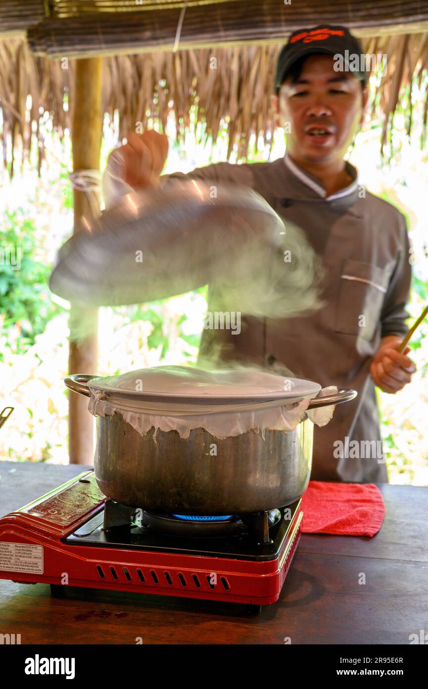 Chef e tutor dimostrano come cucinare la carta di riso utilizzata per panini e spaghetti presso la scuola di cucina Red Bridge alla periferia di Hoi An, in Vietnam. Foto Stock