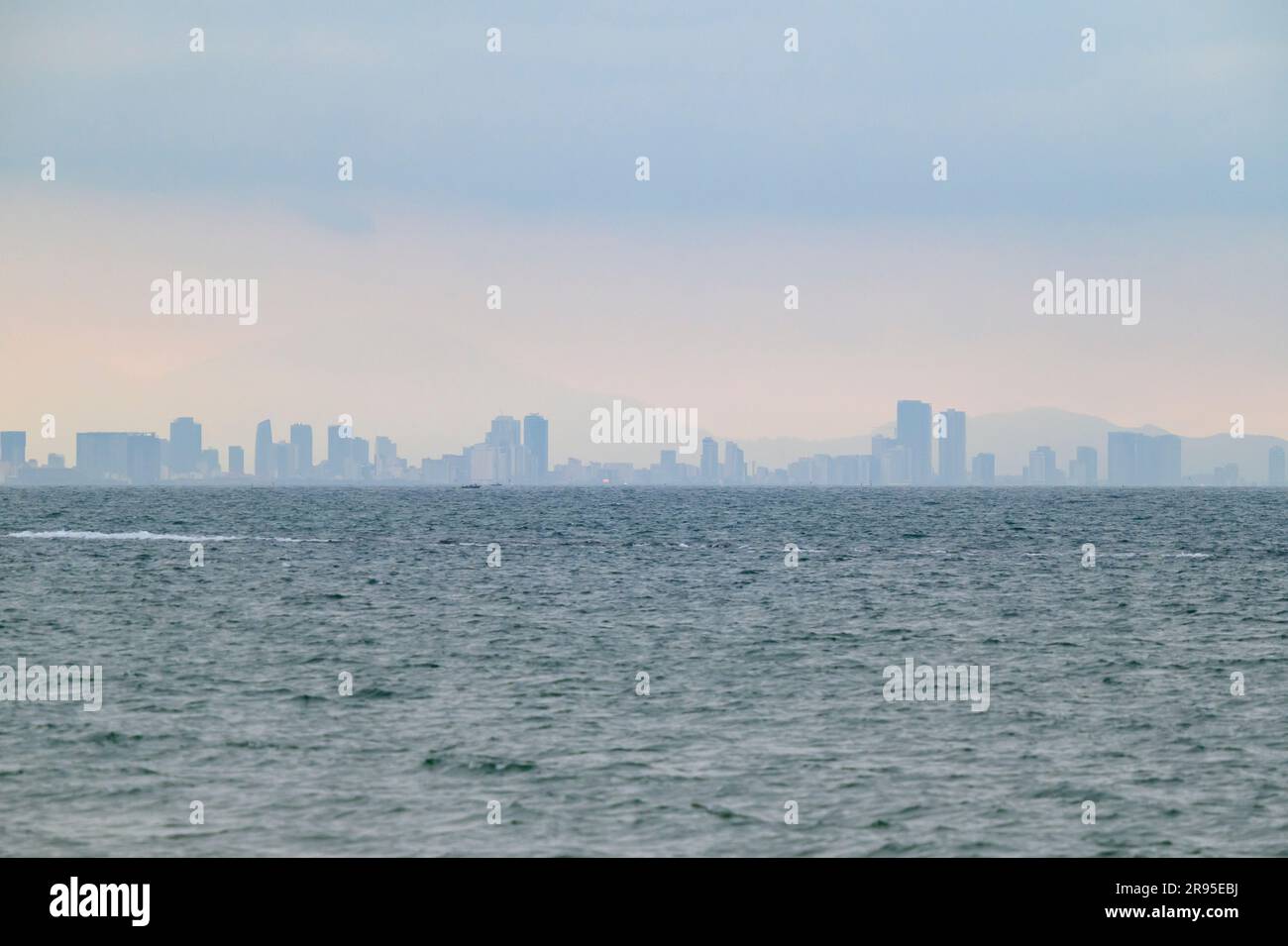 Vista sulla baia del Mare del Vietnam orientale fino allo skyline di da Nang dalla spiaggia di Hoi An, Vietnam. Foto Stock