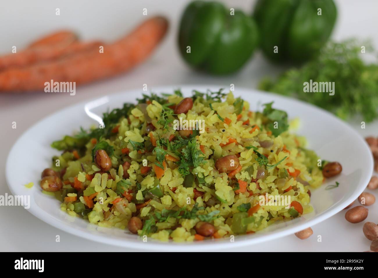 Il Poha vegetale è una colazione veloce o uno spuntino a base di riso sbattuto o di riso appiattito lungo arachidi, carote e peperoncini. Il riso viene parboiled prima del latte Foto Stock