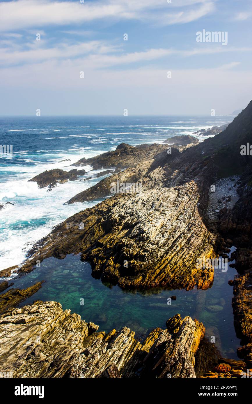 Guardando verso il basso una piscina di marea color turchese scura lungo la costa rocciosa di Tsitsikamma, nella Garden Route Sud Africa. Foto Stock