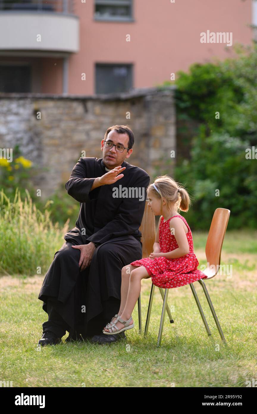 Un prete che dà assoluzione a un bambino durante la confessione. Il bambino si sta preparando per la prima Santa Comunione. Foto Stock