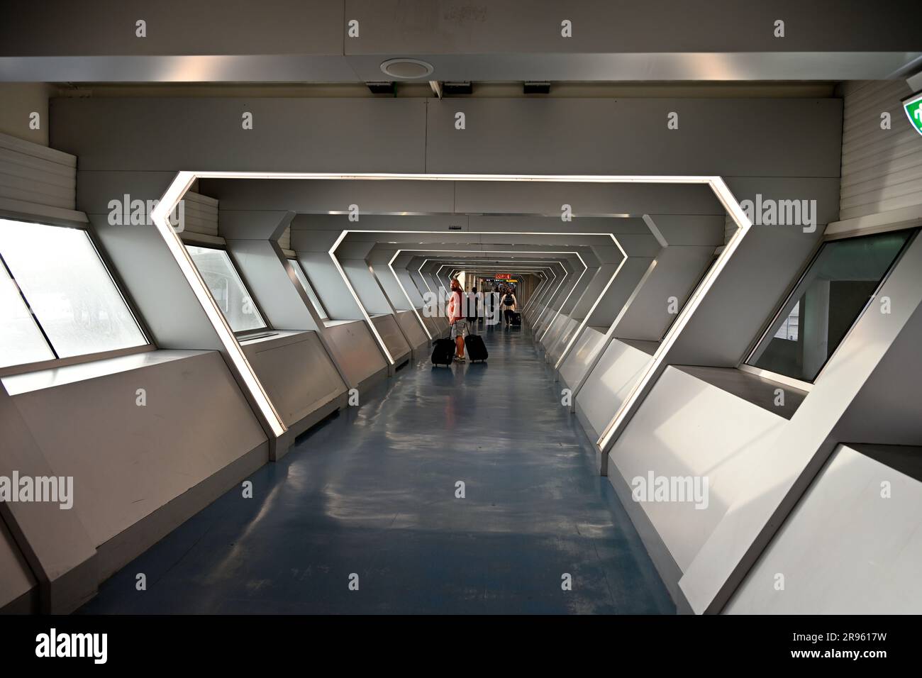 Tunnel dell'età quasi spaziale con persone in lontananza all'aeroporto di Porto, in Portogallo Foto Stock