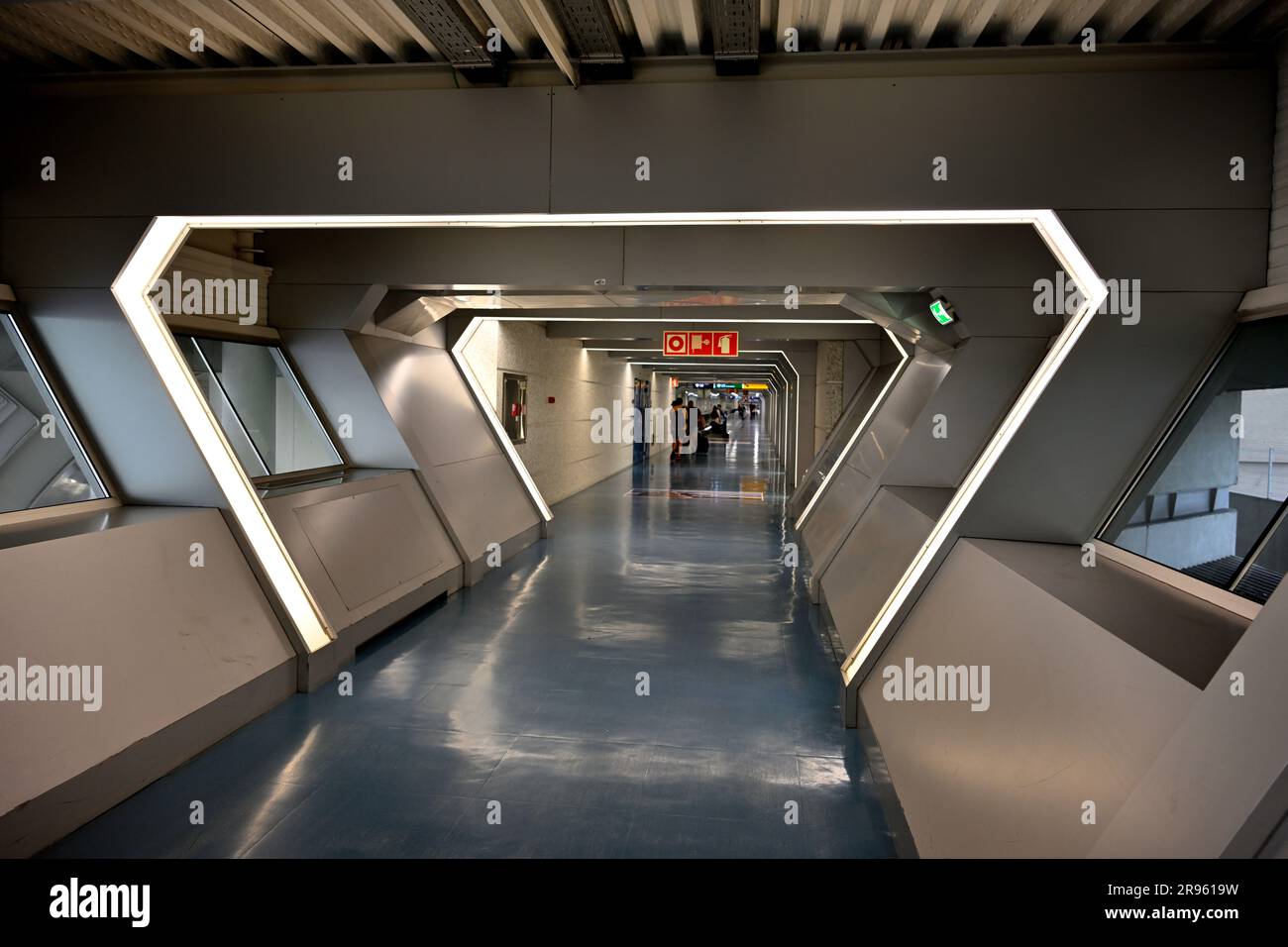Tunnel dell'età quasi spaziale con persone in lontananza all'aeroporto di Porto, in Portogallo Foto Stock
