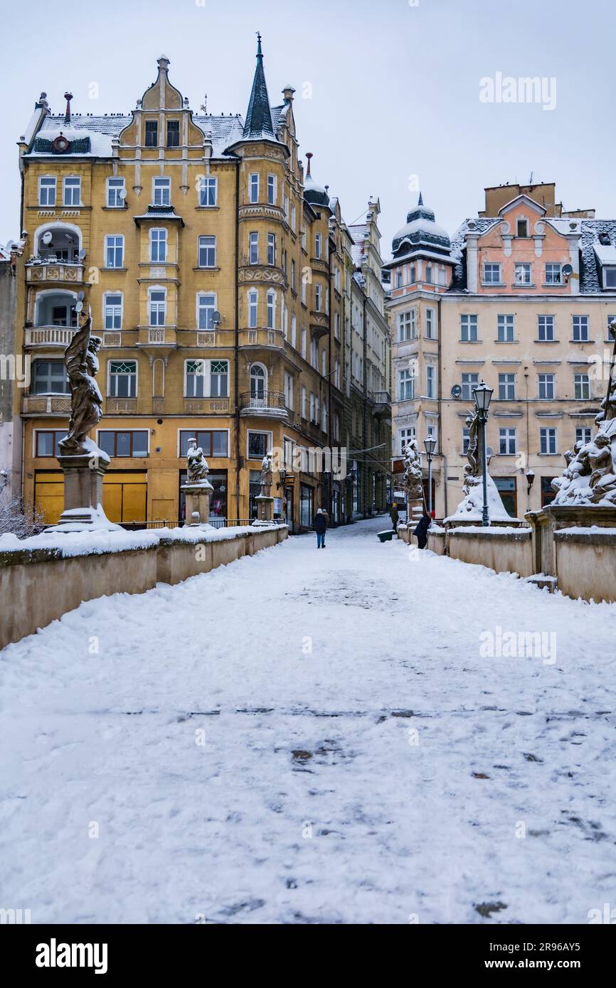 Klodzko, Polonia - gennaio 2023: Piccolo ponte gotico sul fiume Mlynowka situato nel centro della città e coperto da neve fresca in inverno Foto Stock