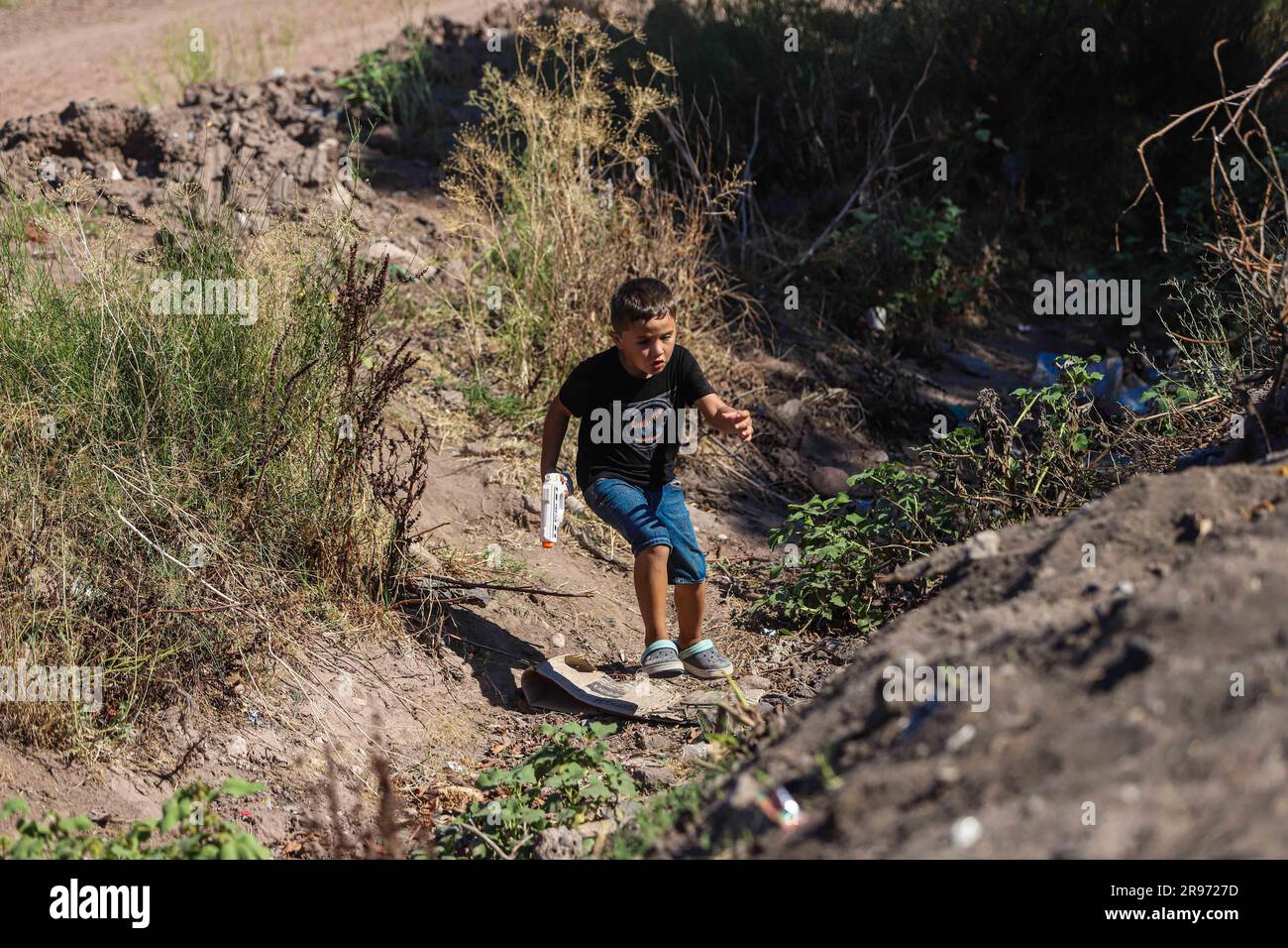 Un ragazzo corre attraverso il canale creek con una pistola giocattolo nella comunità di Navovaxia nel comune di Huatabampo Sonora Messico. Mayo Tribe Community (© foto: LuisGutierrez / NortePhoto.com) un Niño corre por el Canal de arroyo con una pistola de juguete en la comunidad de Navovaxia en el municipio de Huatabampo Sonora Messico. Comunidad de la tribu Mayo (© foto: LuisGutierrez / NortePhoto.com) Foto Stock