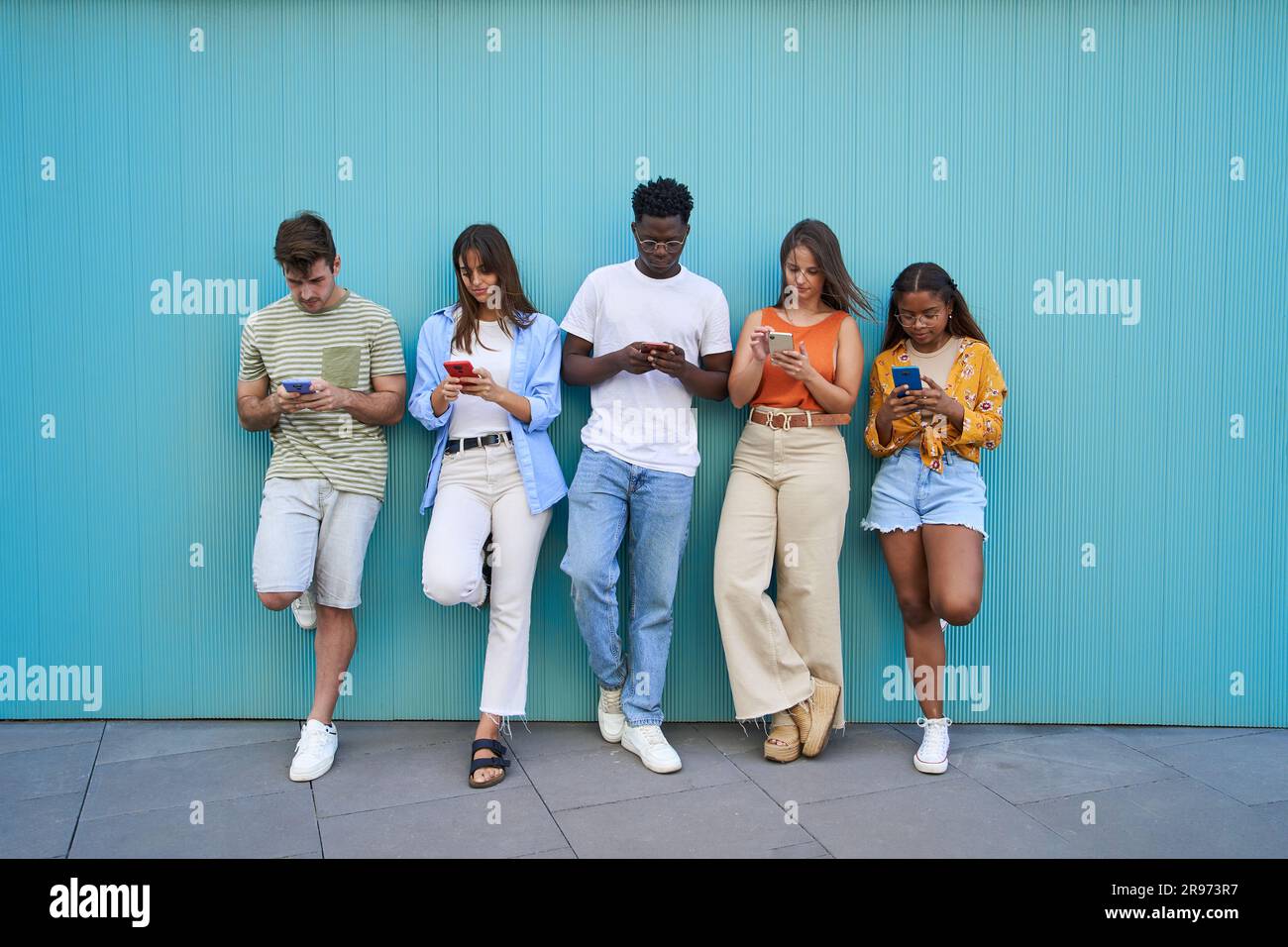 Gruppo di adolescenti multirazziali che chiacchierano online e controllano i social media nel cyberspazio. Foto Stock