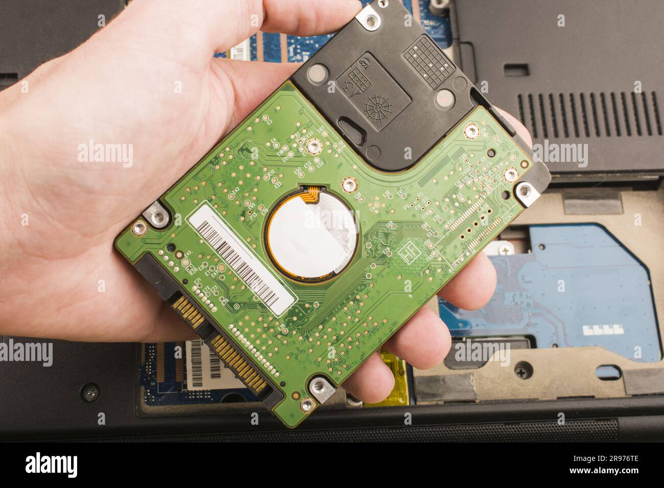 cyber data attack concept : computer portatile rotto, crash della scheda madre, memoria hard disk problemi hardware elettronici su desktop bianco, backup informazioni manuten Foto Stock