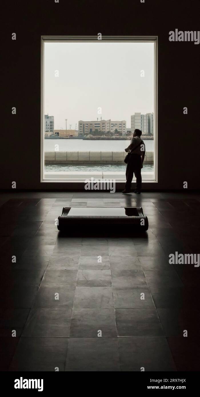 L'uomo guarda dalla finestra al Museo del Louvre, Abu Dhabi, Emirati Arabi Uniti Foto Stock