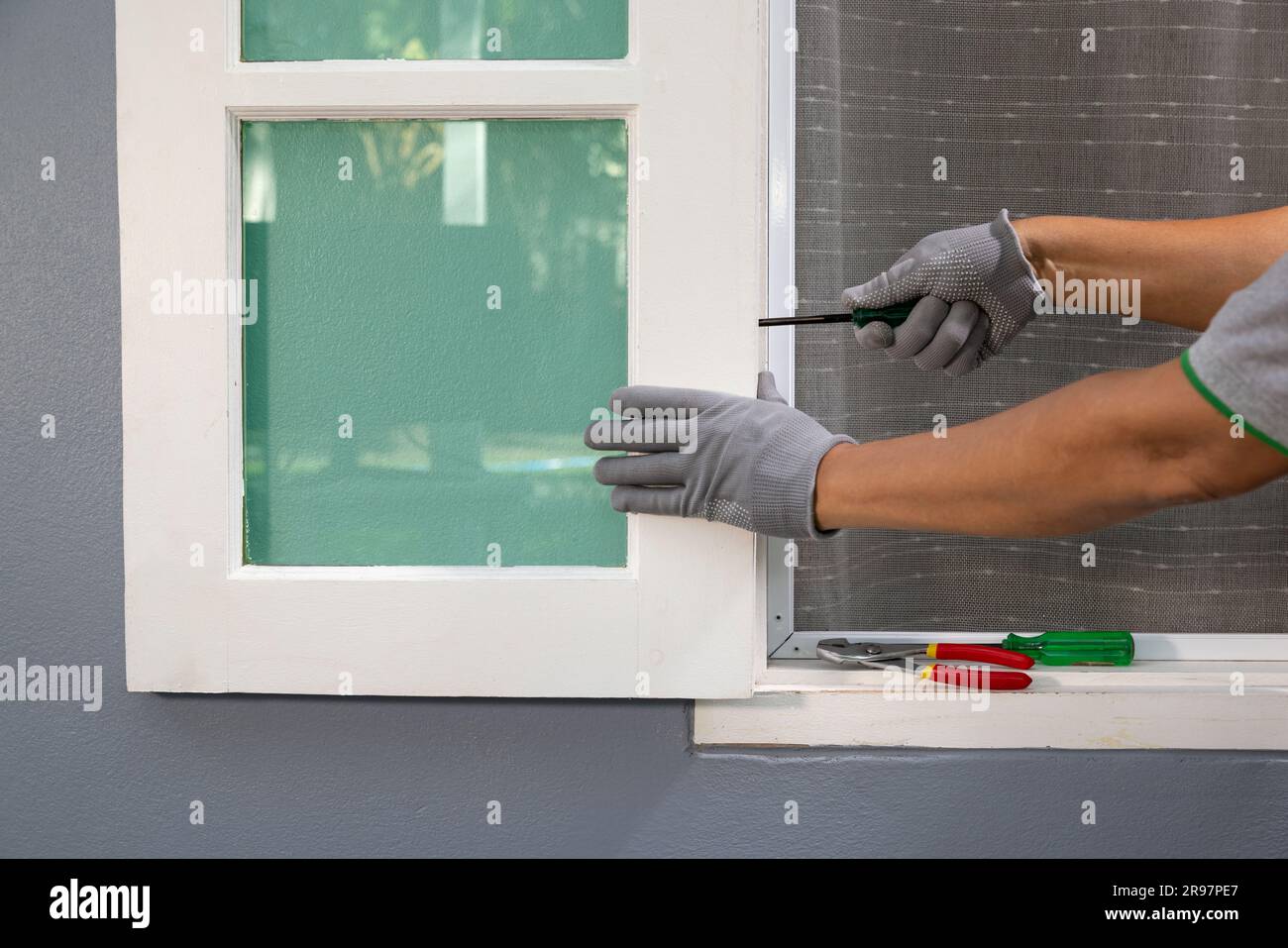 Operaio edile che ripara la finestra di legno dopo la tempesta. Foto Stock