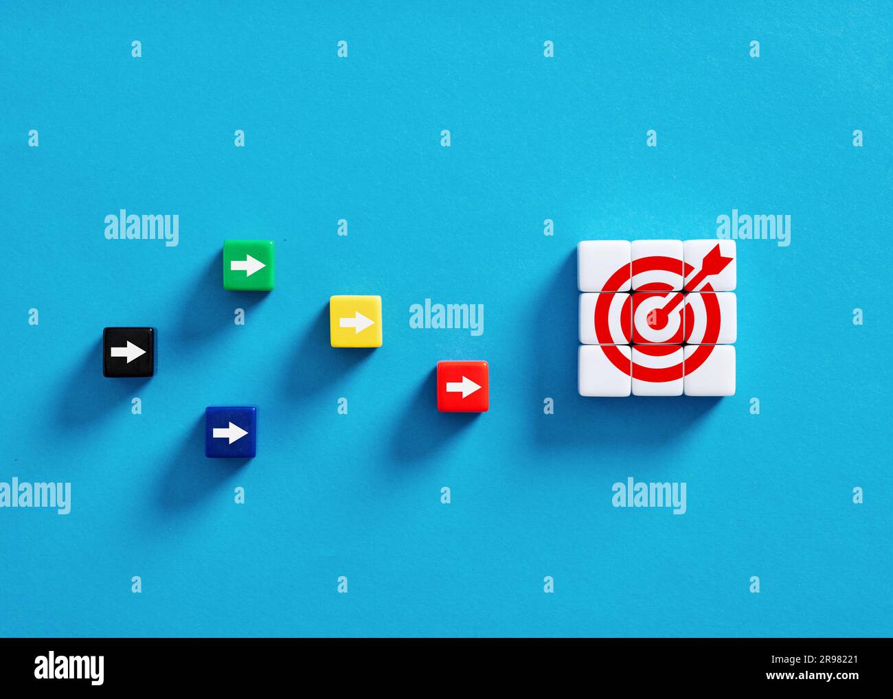 Concorrenza per raggiungere gli obiettivi aziendali. Definizione degli obiettivi, prestazioni e strategia. Cubi colorati con obiettivi e simboli freccia. Foto Stock