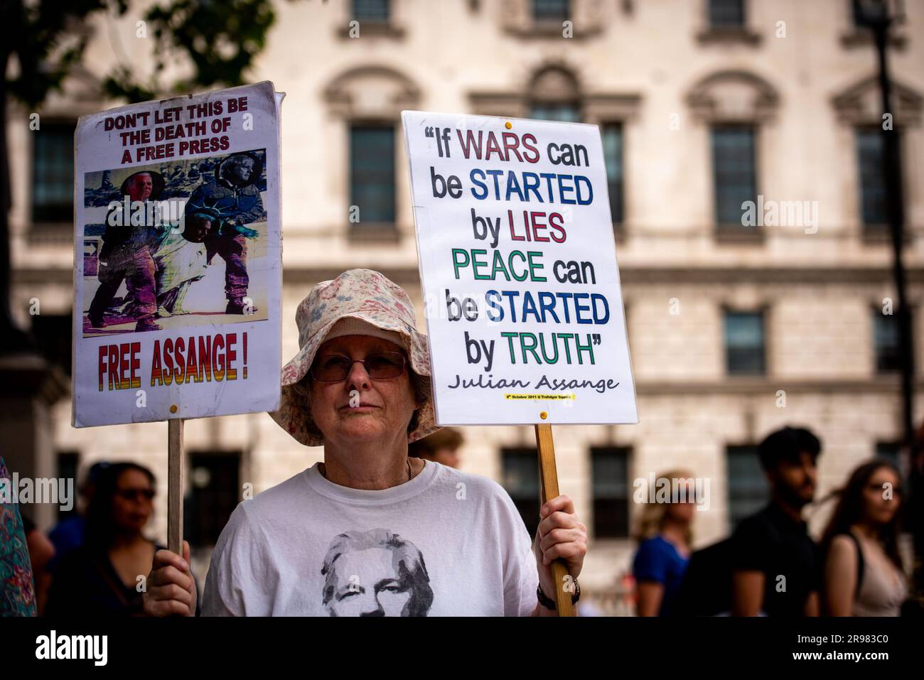 Un protestore tiene cartelli durante il “qualcosa da dire?” Protesta gratuita di Julian Assange a Parliament Square a Londra. "Qualcosa da dire?" È una scultura in bronzo a grandezza naturale che ritrae tre figure, ognuna in piedi su una sedia dell'artista Davide Dormino. La quarta sedia è vuota perché è la nostra sedia. Quella che ci ha permesso di esprimere noi stessi o semplicemente di stare accanto a Edward Snowden, Julian Assange e Chelsea Manning, che hanno avuto il coraggio di dire di no all'intrusione della sorveglianza globale e alle bugie che portano alla guerra. Foto Stock