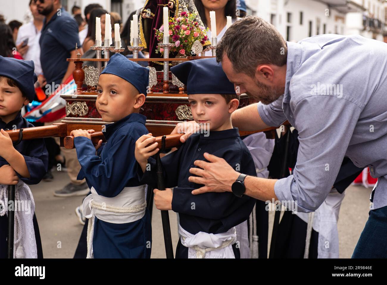 Un uomo che abbraccia un ragazzino alle processioni religiose a Popayan su Domingo de Ramos Foto Stock
