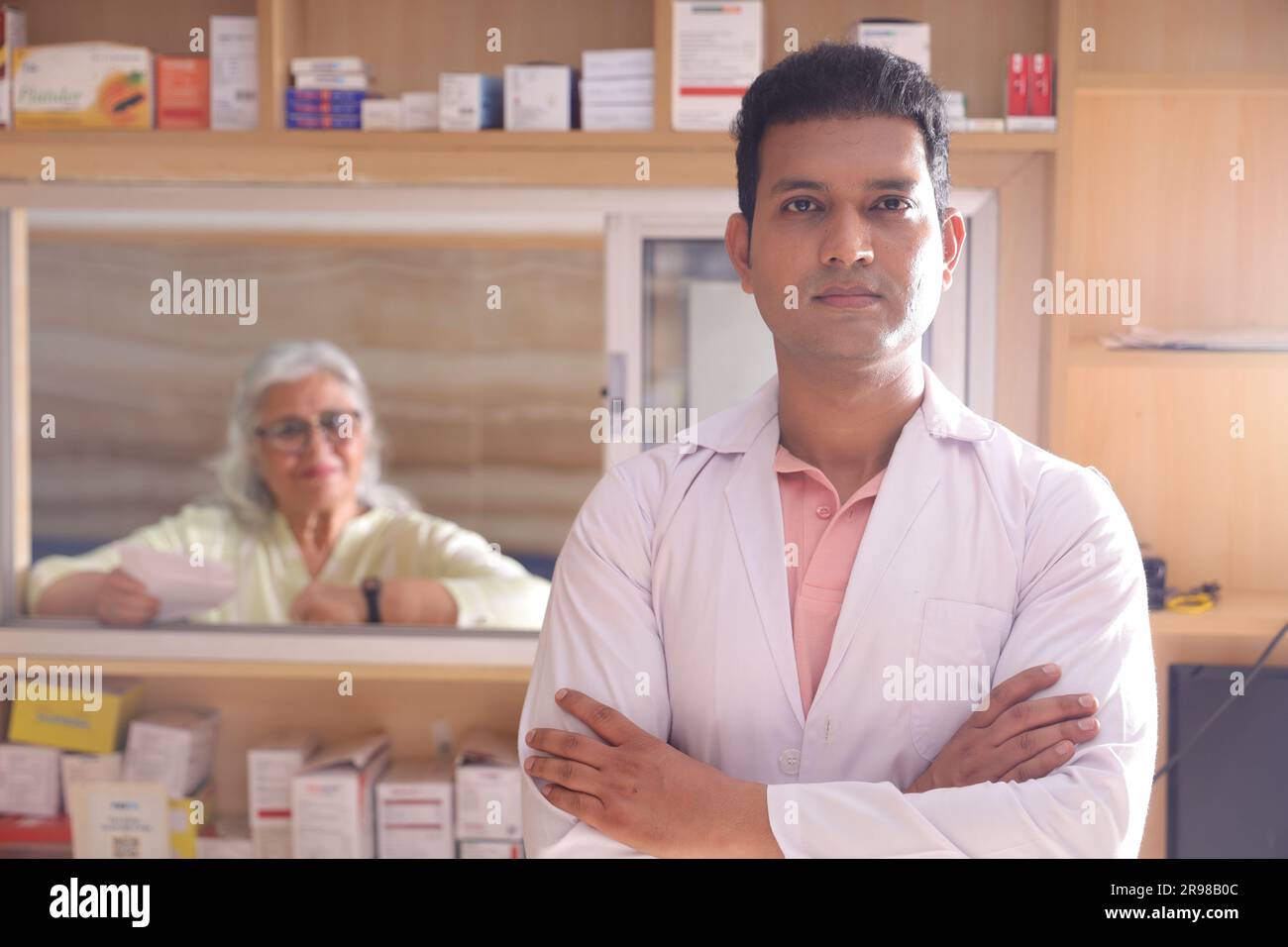 uomo chimico in piedi in farmacia - farmacia. Primo piano del farmacista presso la farmacia dell'ospedale. Assistenza ai clienti, cliente Old lady al banco. Foto Stock