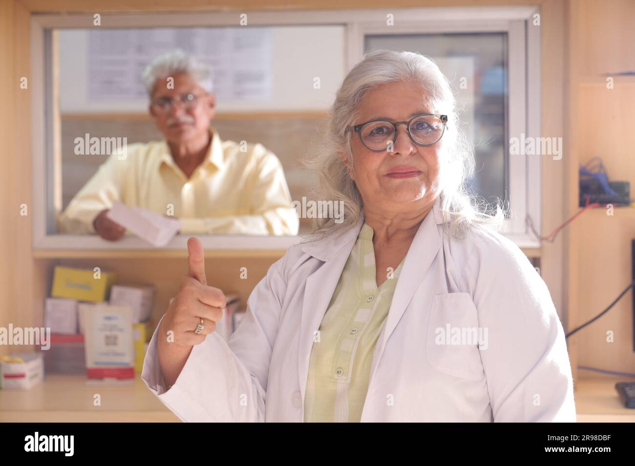 uomo chimico in piedi in farmacia - farmacia. Primo piano del farmacista presso la farmacia dell'ospedale. Assistenza ai clienti, cliente anziano al banco. Foto Stock