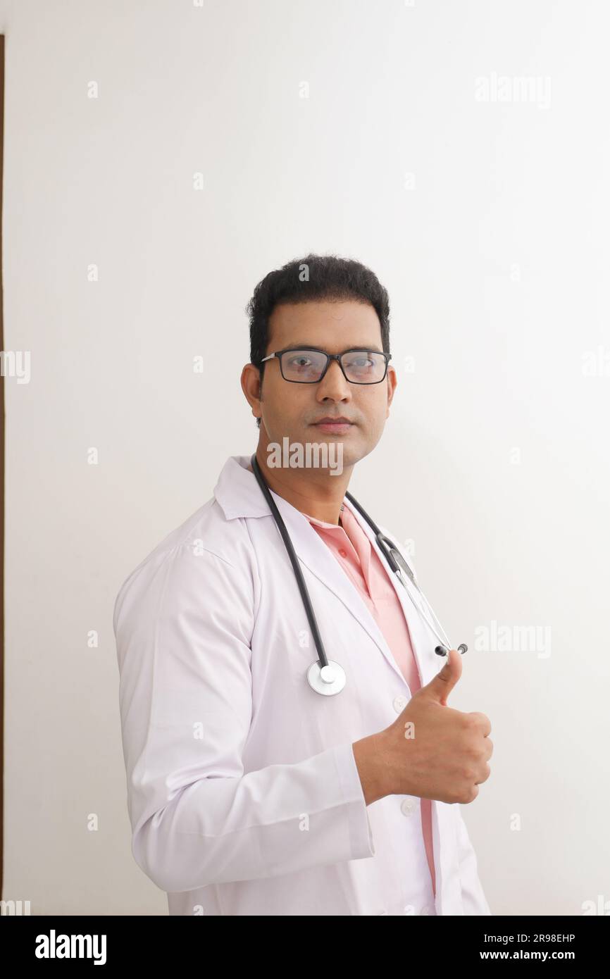 Medico anziano in camice da laboratorio con le braccia incrociate su sfondo bianco. Felice medico indiano in cappotto bianco. sicuro di sé. Foto Stock