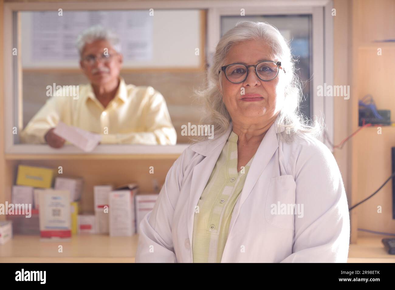 uomo chimico in piedi in farmacia - farmacia. Primo piano del farmacista presso la farmacia dell'ospedale. Assistenza ai clienti, cliente anziano al banco. Foto Stock