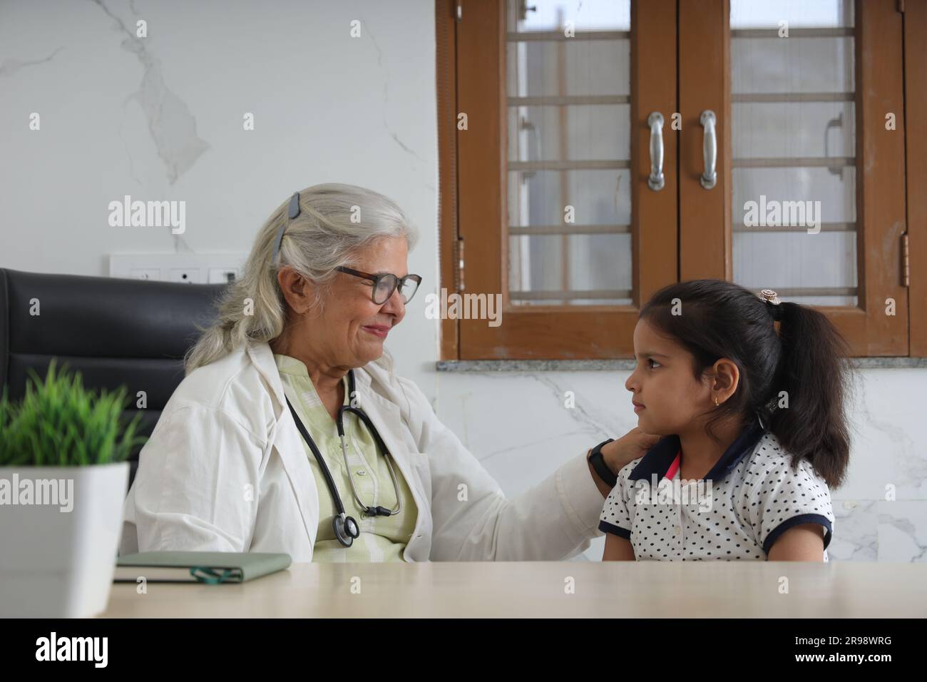 famiglia felice visita medico per consultazione personale con la loro figlia, bambina in ospedale, check-up, cabina, ufficio, salute consapevole, premuroso. Foto Stock