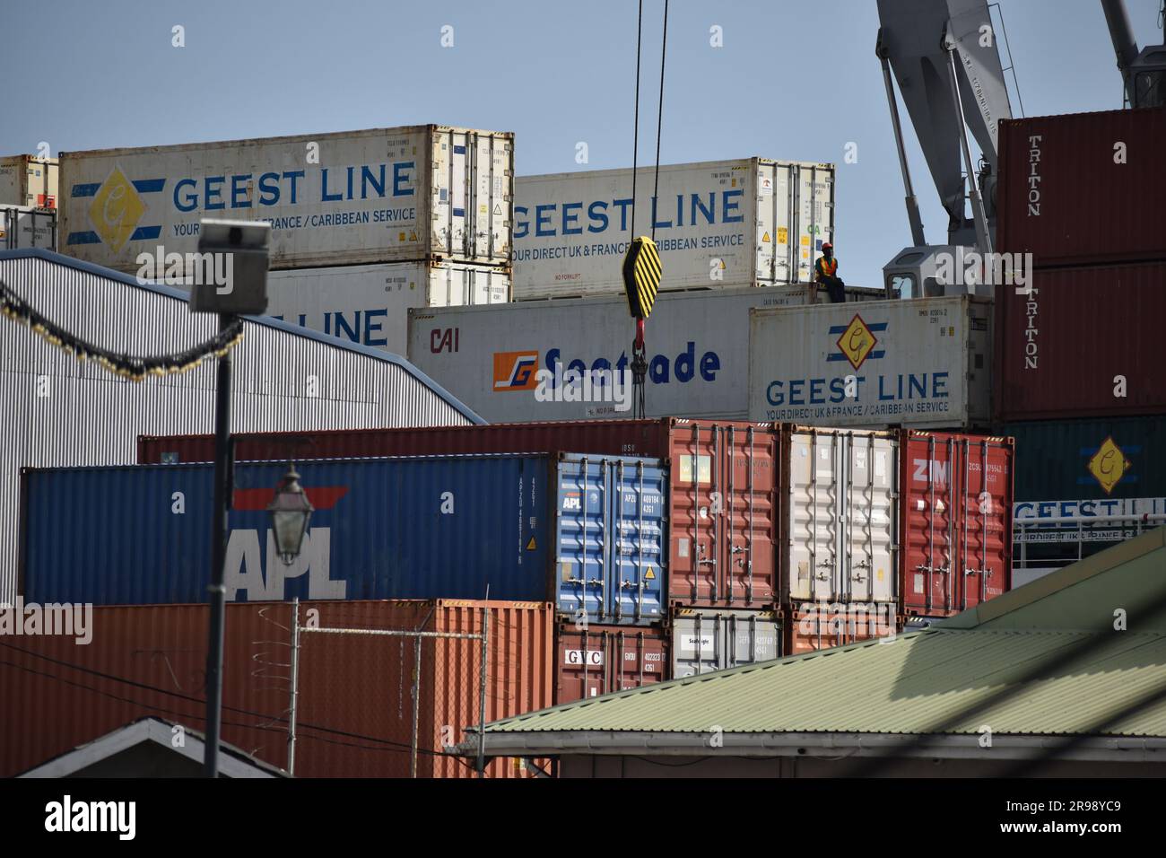Contenitori per spedizioni nel porto di St. George's, Grenada, con contenitori Geest Line, una gru e infrastrutture logistiche portuali caraibiche. Foto Stock