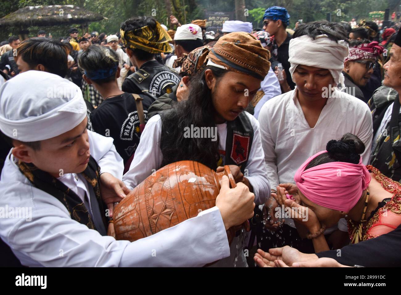 Bandung Regency, Giava Occidentale, Indonesia. 25 giugno 2023. Gli indigeni si lavano il viso con acqua Santa durante la tradizionale cerimonia culturale Ngertakeun Bumi Lamba sul Monte Tangkuban Parahu. Vari leader tradizionali e religiosi indonesiani hanno preso parte all'evento culturale Sundanese nel quadro di un rituale cerimoniale di armonizzazione degli esseri umani e della natura come espressione di gratitudine a Dio e all'universo. Crediti: Dimas Rachmatsyah/Alamy Live News Foto Stock