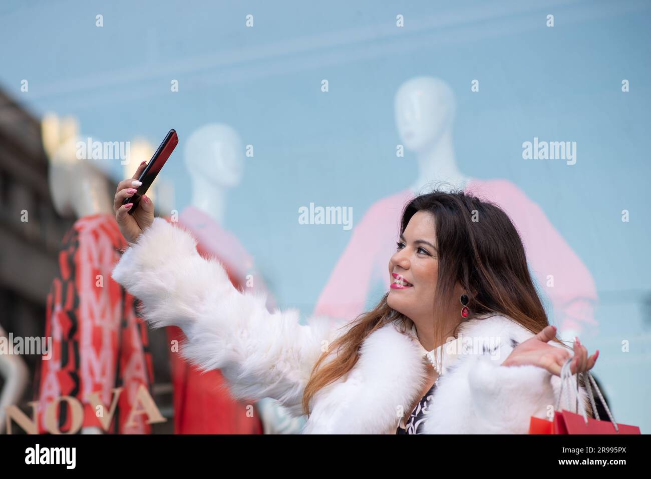 Donna elegante che scatta selfie dopo lo shopping Foto Stock