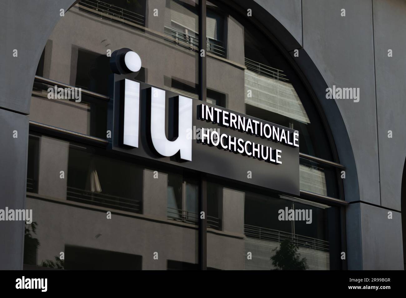 Logo IU Internationale Hochschule (International University of Applied Sciences) su una facciata dell'edificio. L'università offre l'apprendimento a distanza. Foto Stock